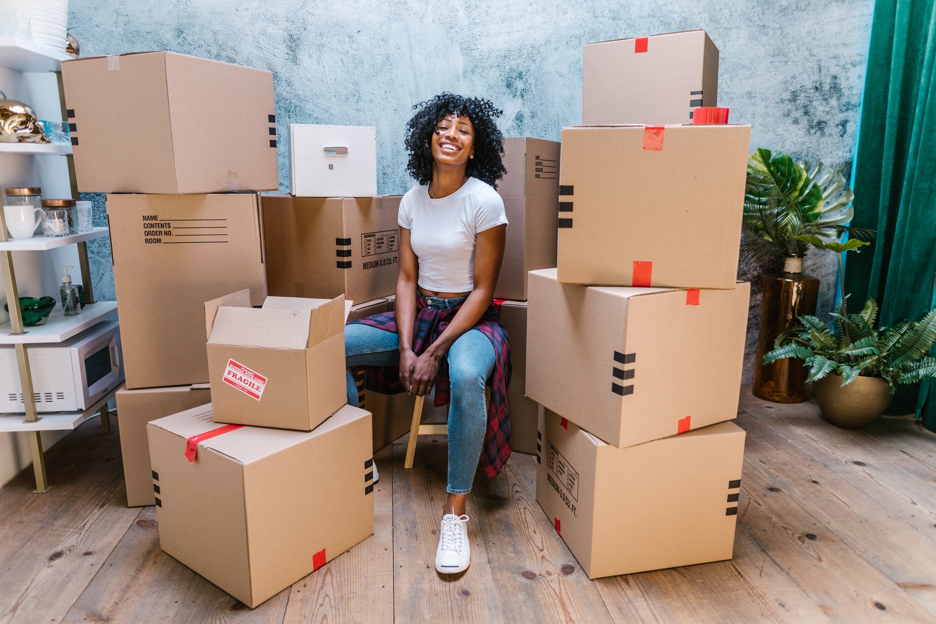 photograph of a woman in a white shirt sitting beside cardboard boxes post college